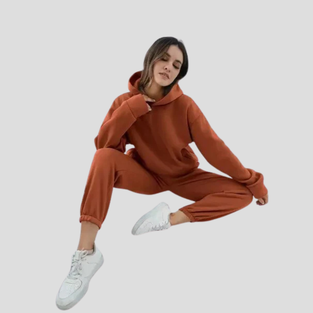 Woman relaxing in a comfy women's hoodie and jogger set, ideal casual winter loungewear ensemble.
