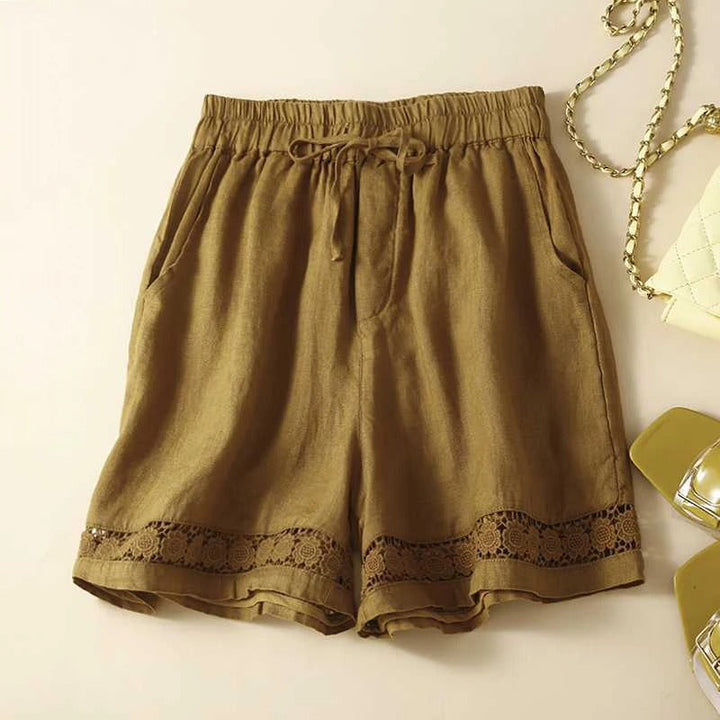Stylish women's relaxed fit shorts featuring an elastic waist, drawstring, and decorative trim details.