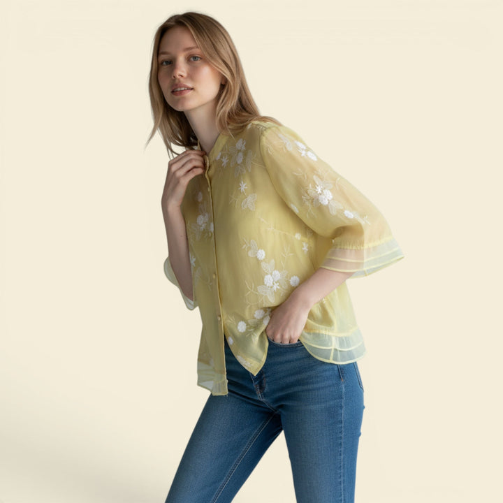Women's relaxed fit summer blouse with delicate floral embroidery and button front.