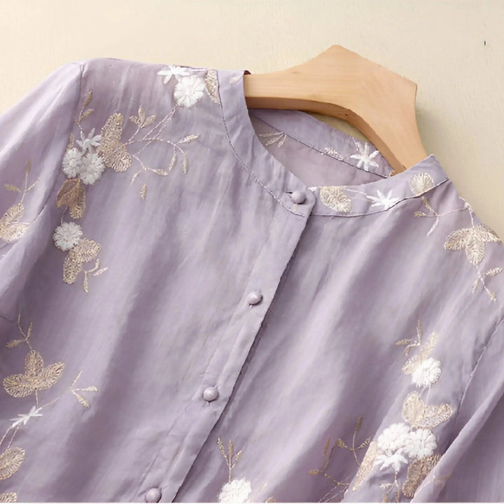 Elegant women's summer blouse, loose fit, featuring delicate floral embroidery detail. Versatile fashion.