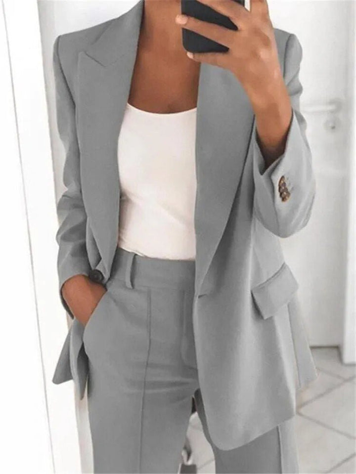 Modern women's two-piece suit: relaxed fit blazer & matching trousers, offering stylish comfort for office wear.