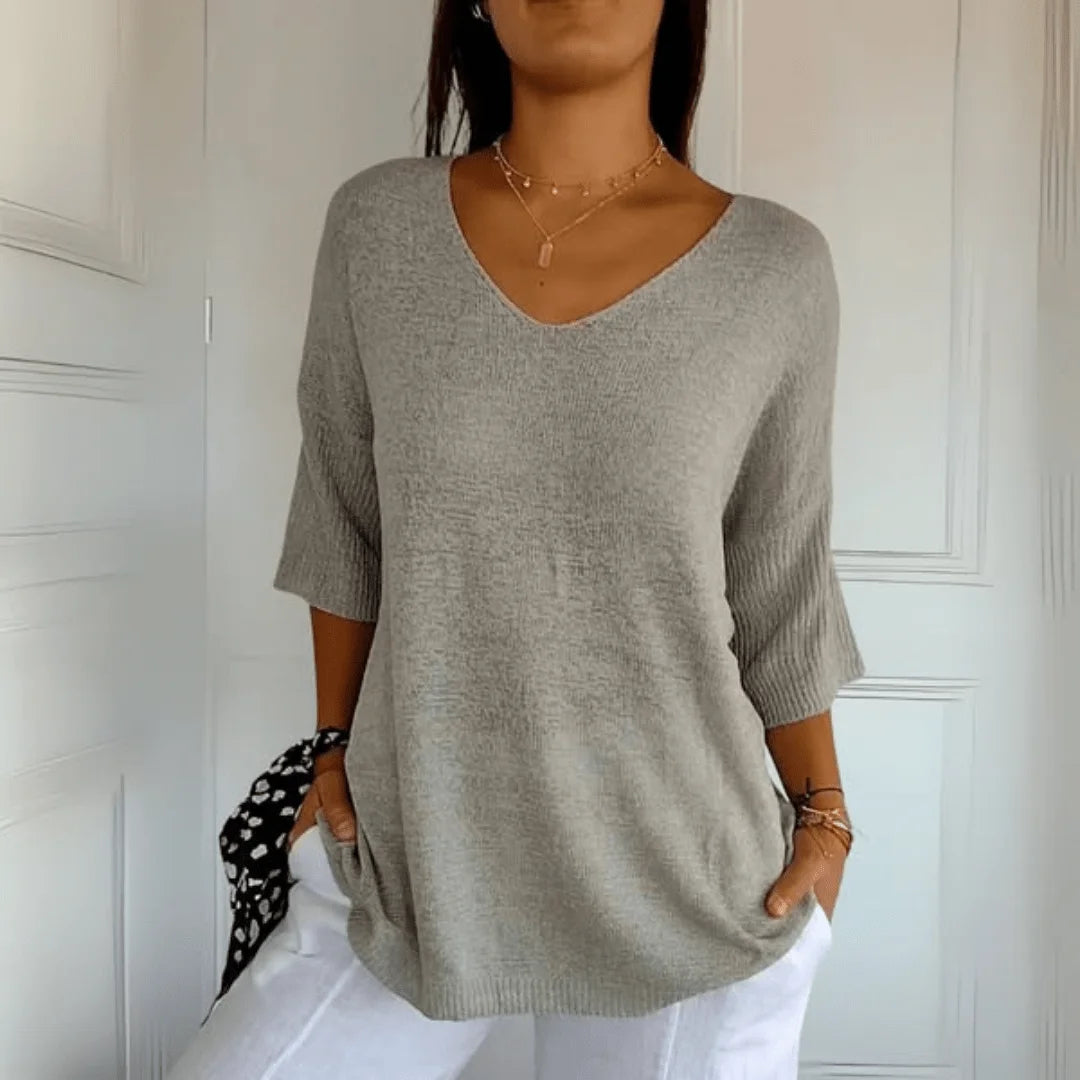Stylish women's V-neck top with 3/4 sleeves, featuring a relaxed fit for versatile spring and summer looks.