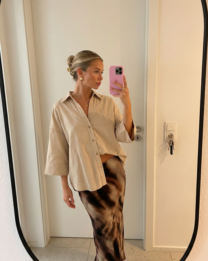 Chic women's oversized button-up blouse with a relaxed fit, versatile for modern everyday wear.