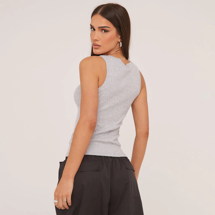 Stylish women's sleeveless top, featuring ripped details and intricate embroidered patterns.
