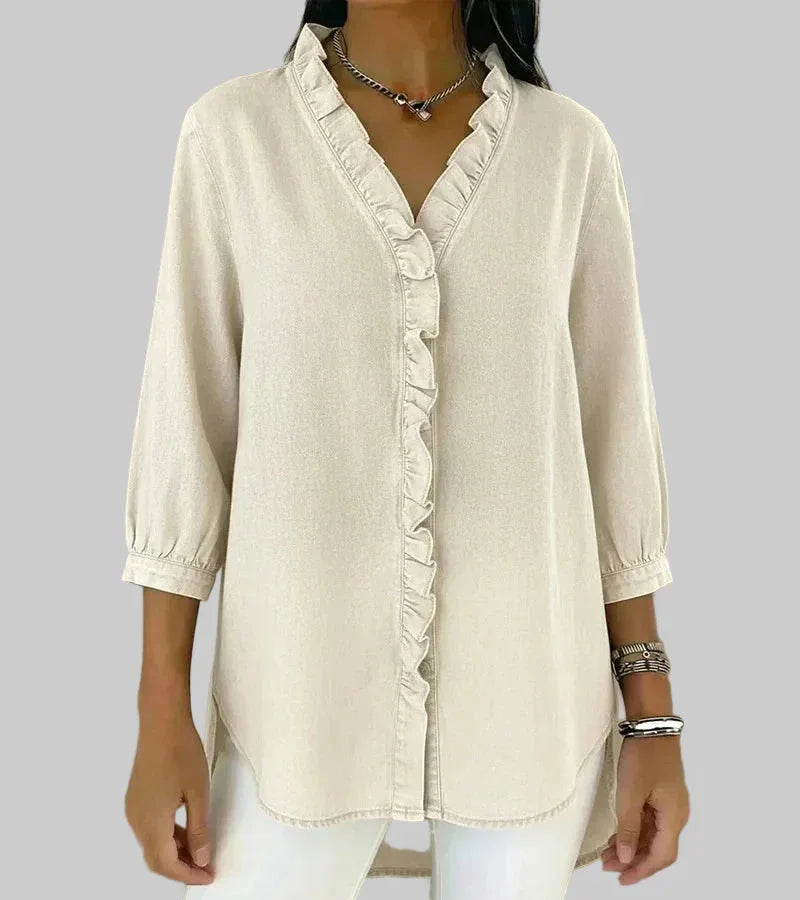 Model wearing a women's ruffle v-neck blouse, showcasing the 3/4 sleeves & elegant hi-low hem. Office wear.