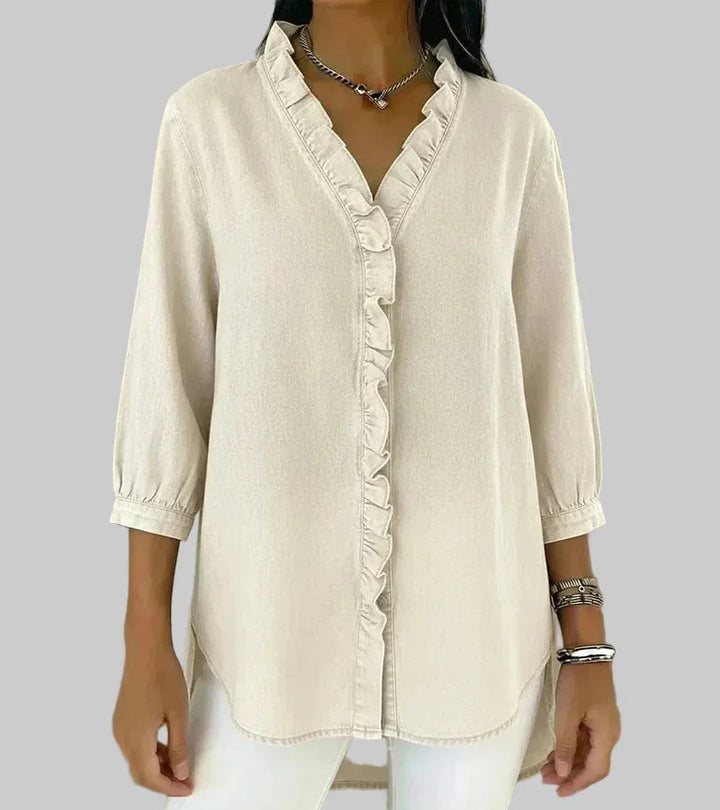 Model wearing a women's ruffle v-neck blouse, showcasing the 3/4 sleeves & elegant hi-low hem. Office wear.