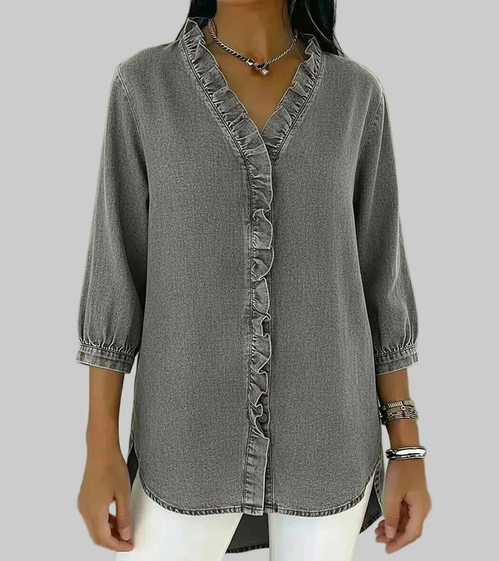 Close-up of the delicate ruffles & v-neck detail on a women's 3/4 sleeve hi-low hem blouse. Spring fashion.