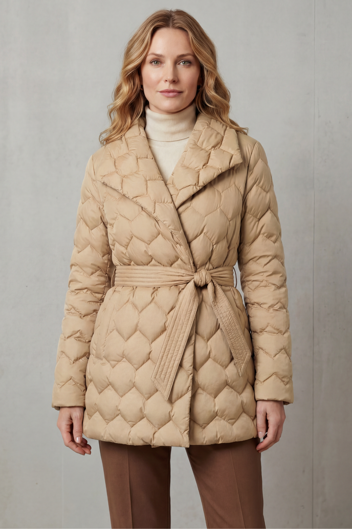 Beige women's sculpted quilted puffer jacket with belt. Modern, warm fall & winter outerwear style.