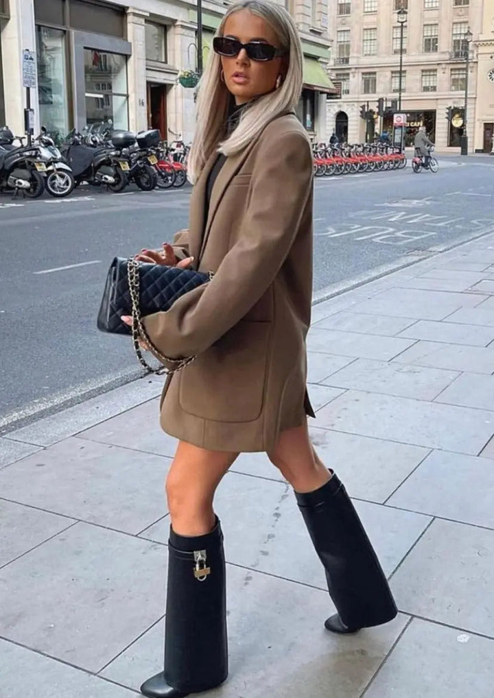 High-shine women's knee-high wedge boots with a unique sculptural heel design.