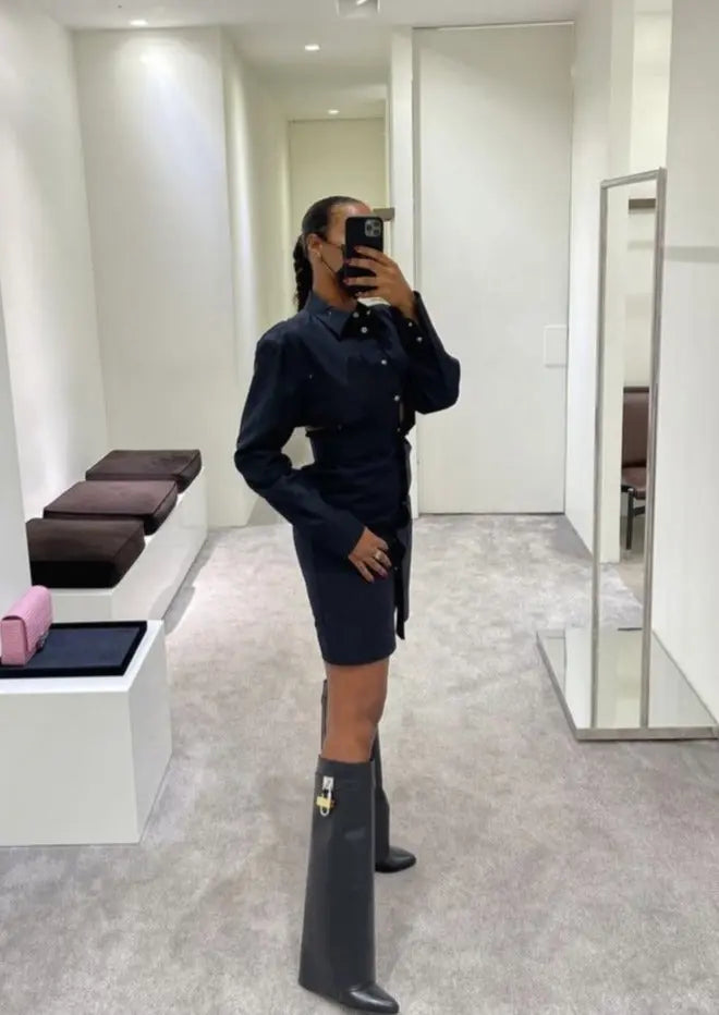 Women's glossy knee-high boots, featuring a distinct sculptural wedge heel.