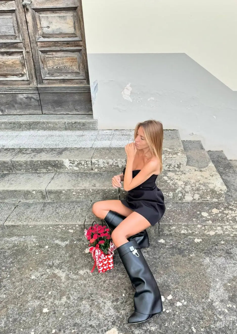 Women's modern knee-high boots: glossy black finish and unique sculptural wedge.