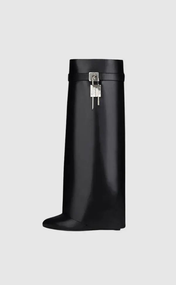 Stylish women's black glossy wedge boots, perfect for a chic street style look.