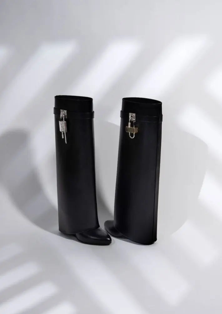 Chic women's winter boots: glossy black, knee-high and sculptural wedge design.