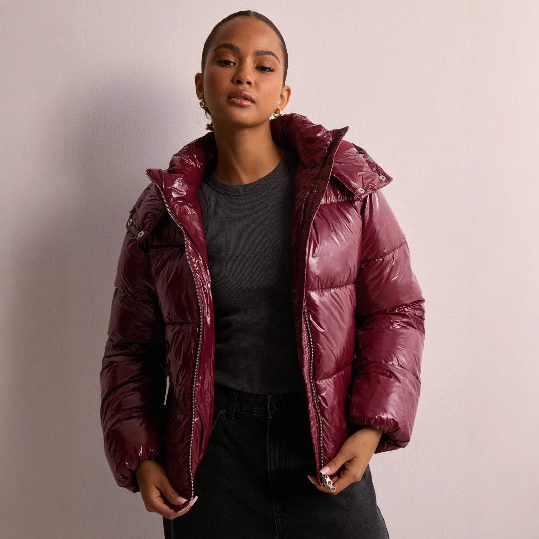 Model wearing a fashionable women's shiny quilted jacket with the hood detached.