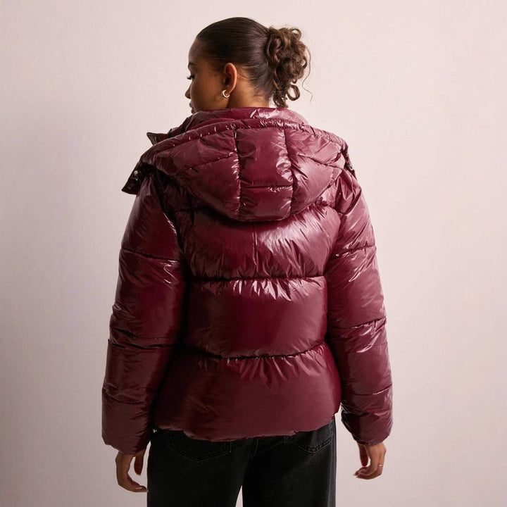 Back view of a women's casual wear quilted jacket, showcasing its shiny finish.