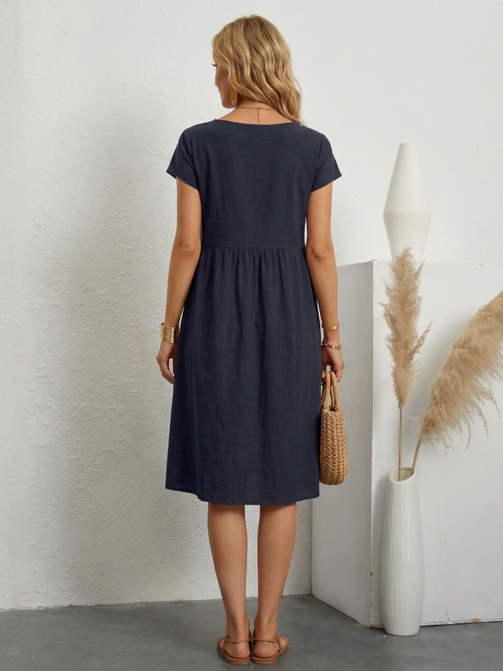 Relaxed fit women's knee-length short sleeve dress with convenient pockets. Versatile for spring/summer casual style.