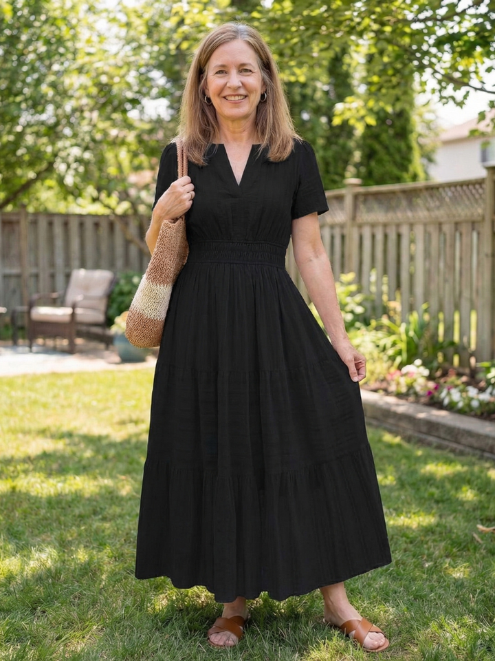 Black women's tiered maxi dress with short sleeves and a smocked waist, offering effortless casual summer style.