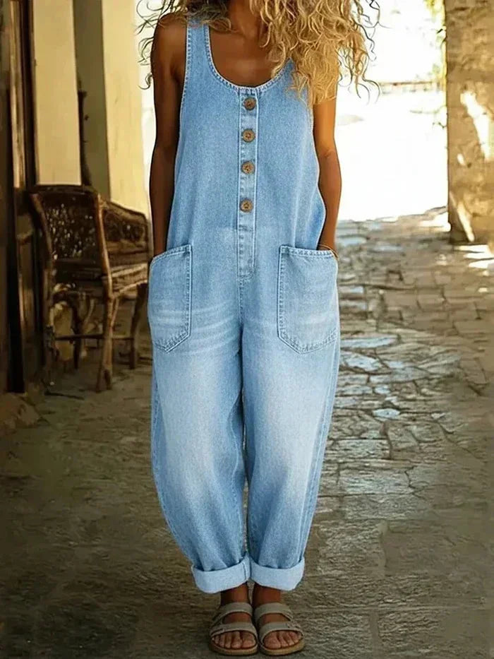 Women's sleeveless denim jumpsuit, loose fit with button front & practical pockets for casual spring/summer wear.