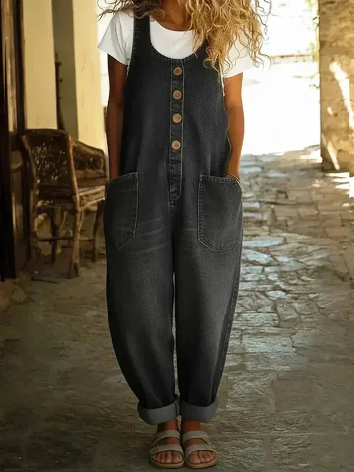 Casual women's button-front denim jumpsuit, sleeveless & loose-fitting, with convenient pockets for effortless summer fashion.