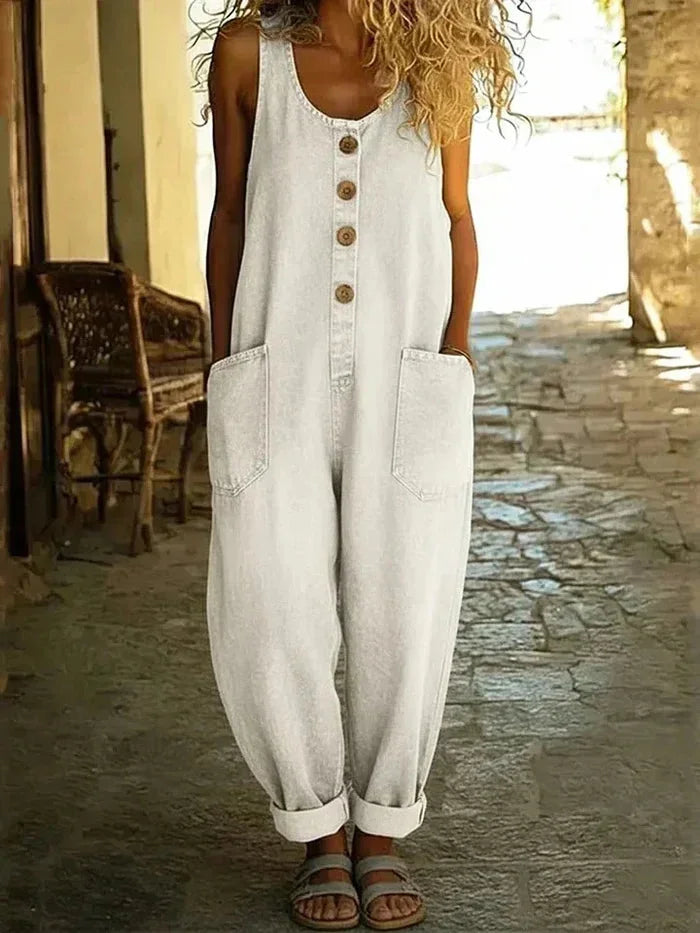 Blue denim women's sleeveless one-piece jumpsuit, loose fit with front buttons & pockets, ideal for spring & summer outfits.