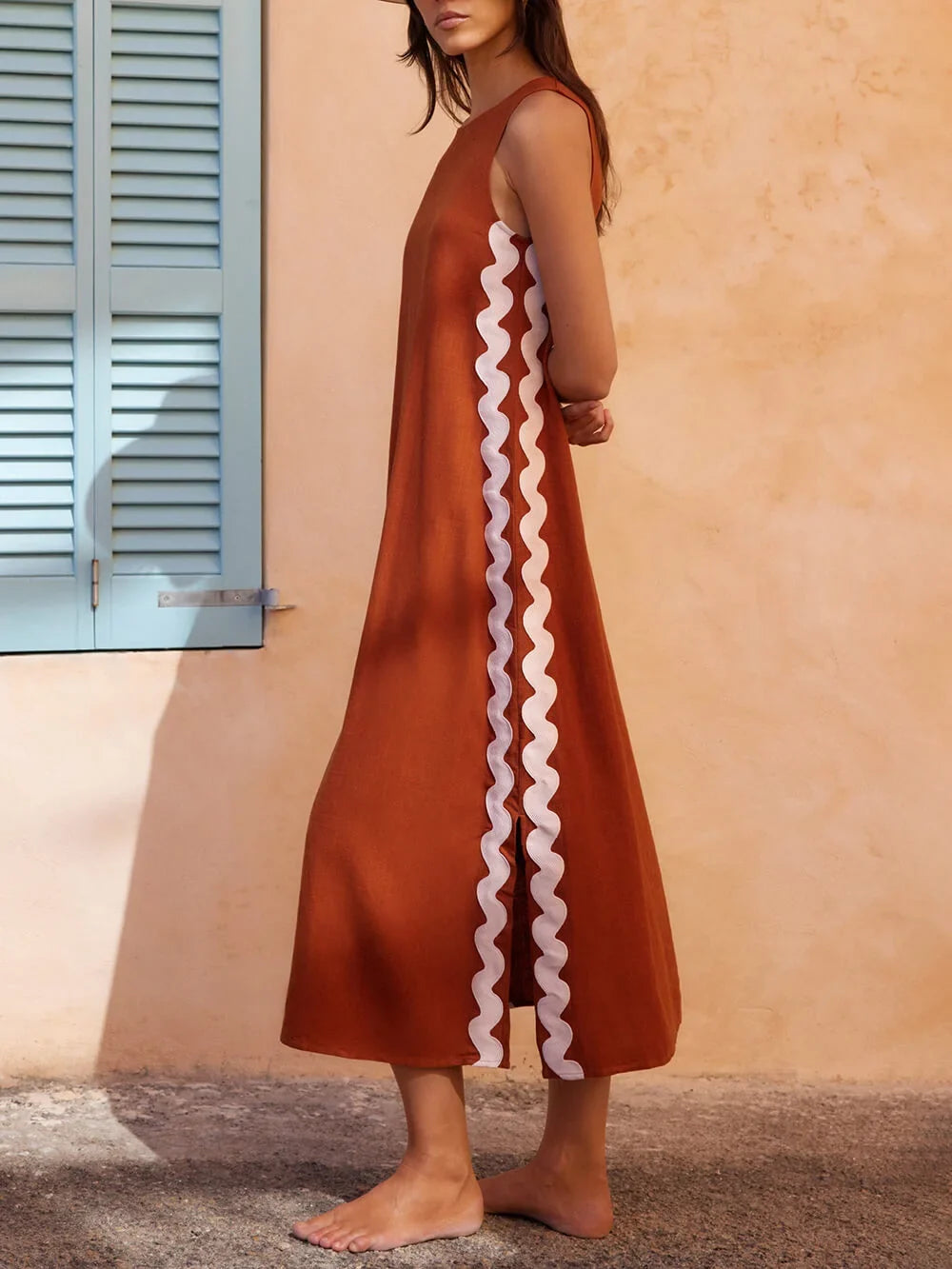 Stylish black midi dress, sleeveless, with unique wavy contrast side trim. Perfect for versatile summer wear.