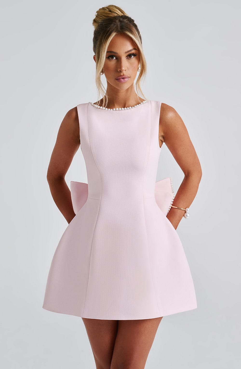Women's sleeveless mini dress with elegant pearl neckline, perfect for cocktails.