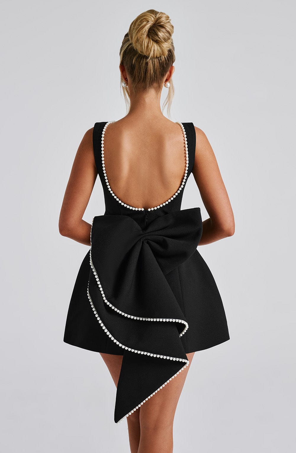 Chic sleeveless mini dress, women's fashion, elegant pearl neckline detail.