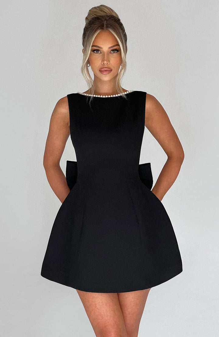 Elegant sleeveless mini dress with pearl neckline, ideal for special occasions.