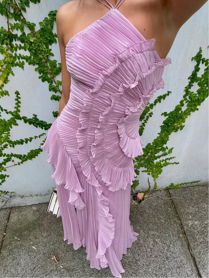 Chic pleated sleeveless wedding guest dress. Long maxi style with a modern asymmetric design.
