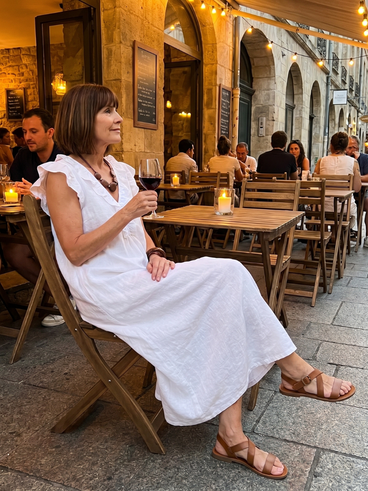 Woman wearing a stylish sleeveless ruffle trim midi dress, enjoying a sunny summer day.