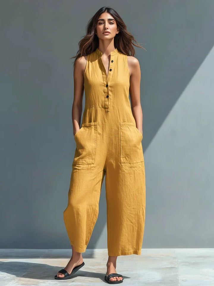 Stylish woman wearing a sleeveless wide-leg jumpsuit with mandarin collar & button detail. Perfect summer fashion.