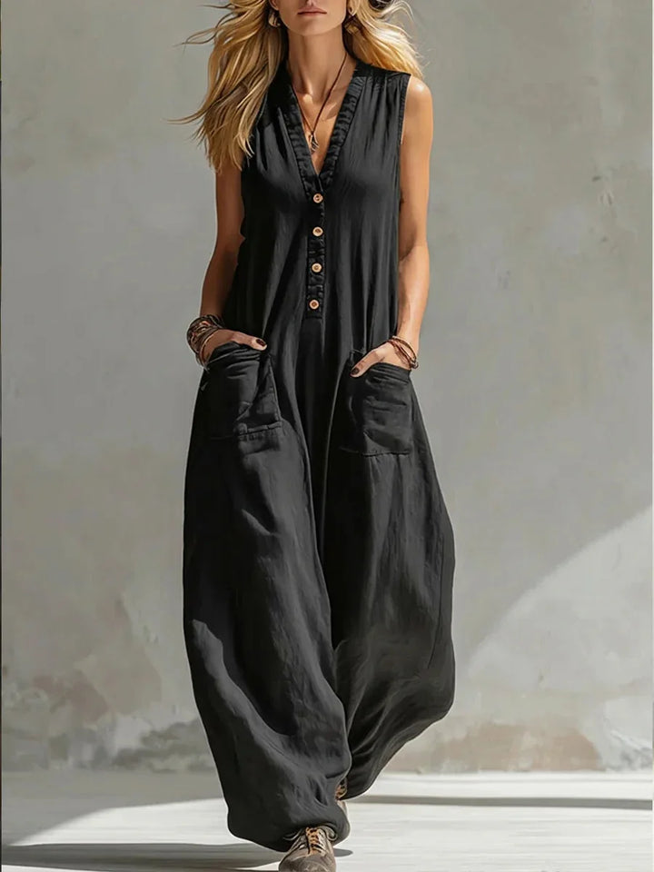 Model wearing a versatile women's sleeveless wide leg jumpsuit with buttoned front & pockets.