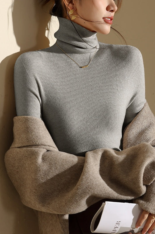 Ribbed women's slim-fit turtleneck sweater, a warm seamless layer for stylish fall and winter outfits.