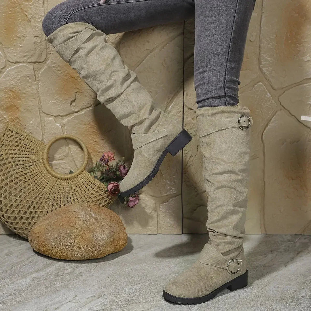 Fashionable women's knee-high slouchy boots. Features a decorative buckle & a robust lug sole for winter wear.