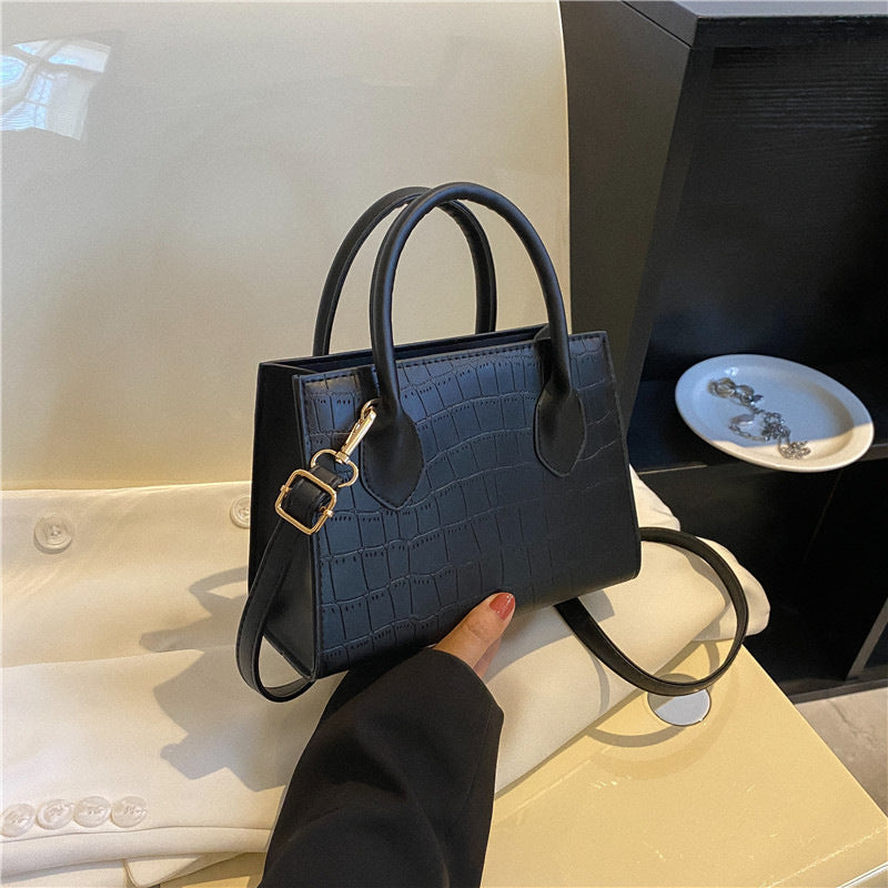 Women's small black clutch handbag, elegant & chic for evening or daily fashion accessory.