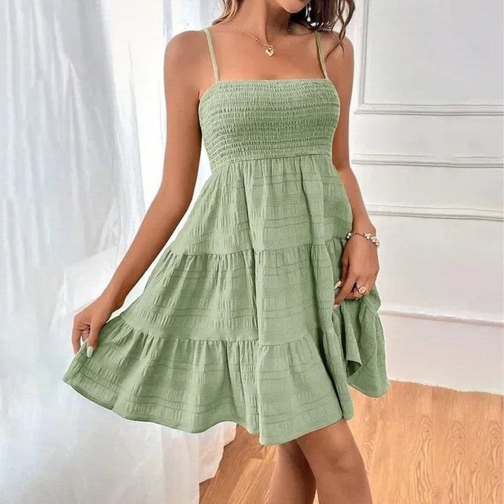 Versatile smocked tiered mini sundress, sleeveless, ideal for beach, vacation, or casual summer outings.
