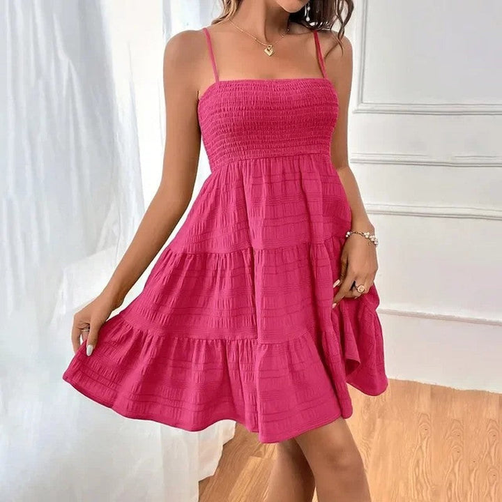 Feminine women's smocked tiered mini sundress, flowy fabric, great for warm weather.