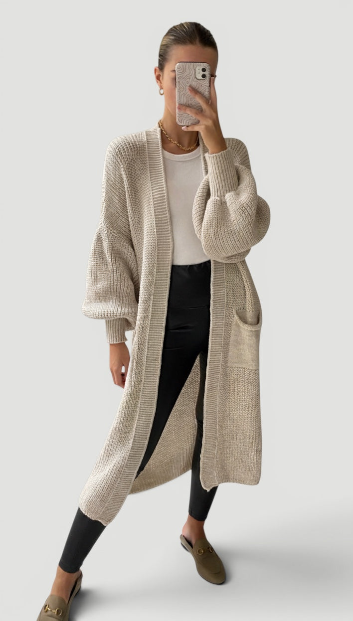 Soft women's sand cardigan featuring trendy bell sleeves & longline cut. Versatile fall fashion & elegant layering.