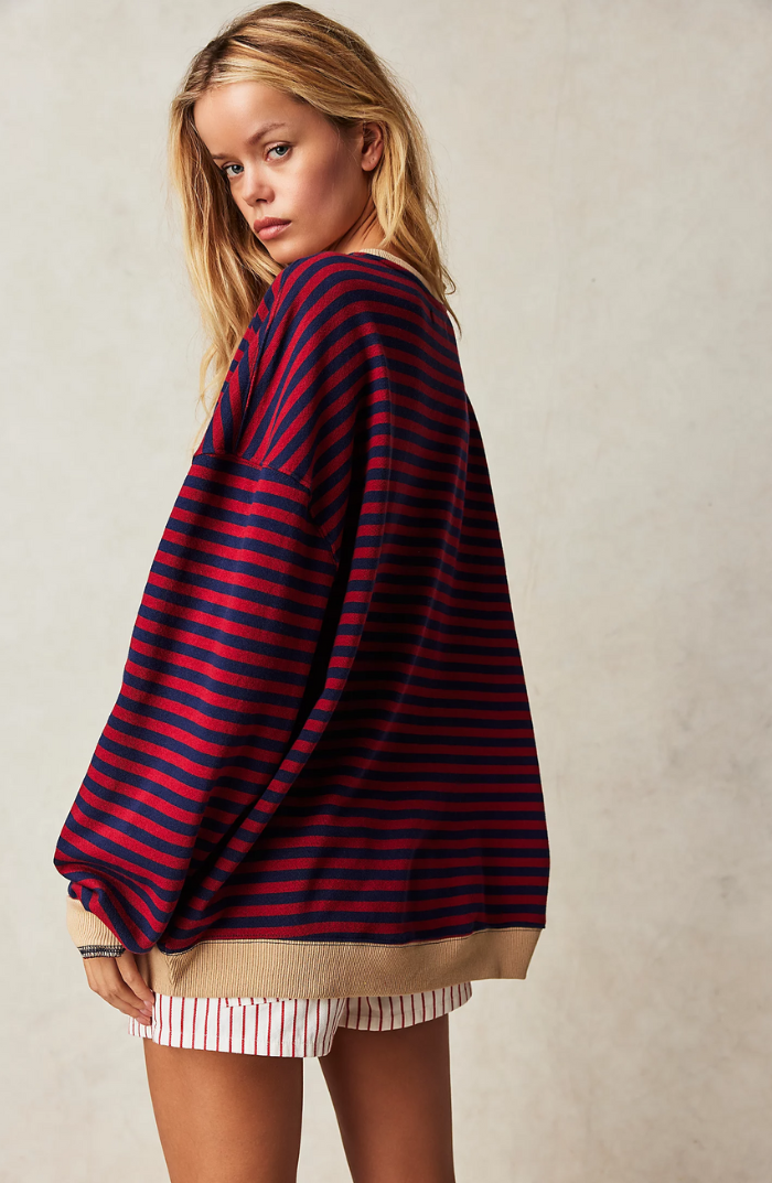 Woman wearing a stylish striped crewneck sweater, showcasing casual elegance & comfort.