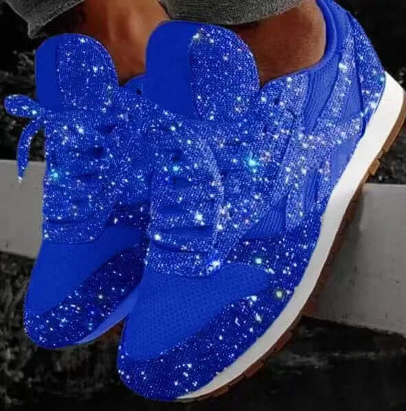 Close-up of women's chunky glitter trainers, featuring a high platform sole & shimmering upper. Fashionable athletic footwear.
