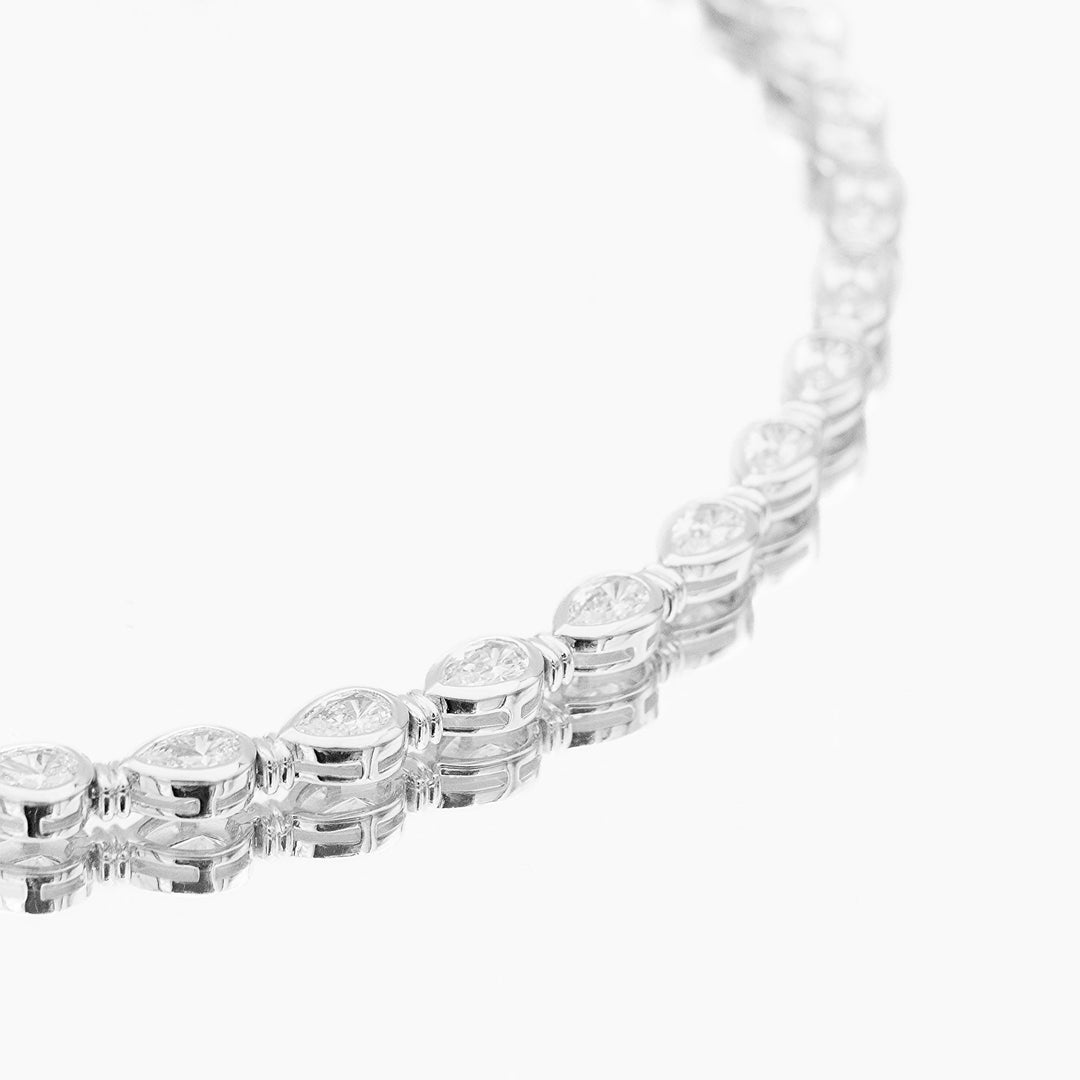 Women's luxury gold vermeil padel bracelet on wrist, featuring sparkling pear stones & sterling silver.