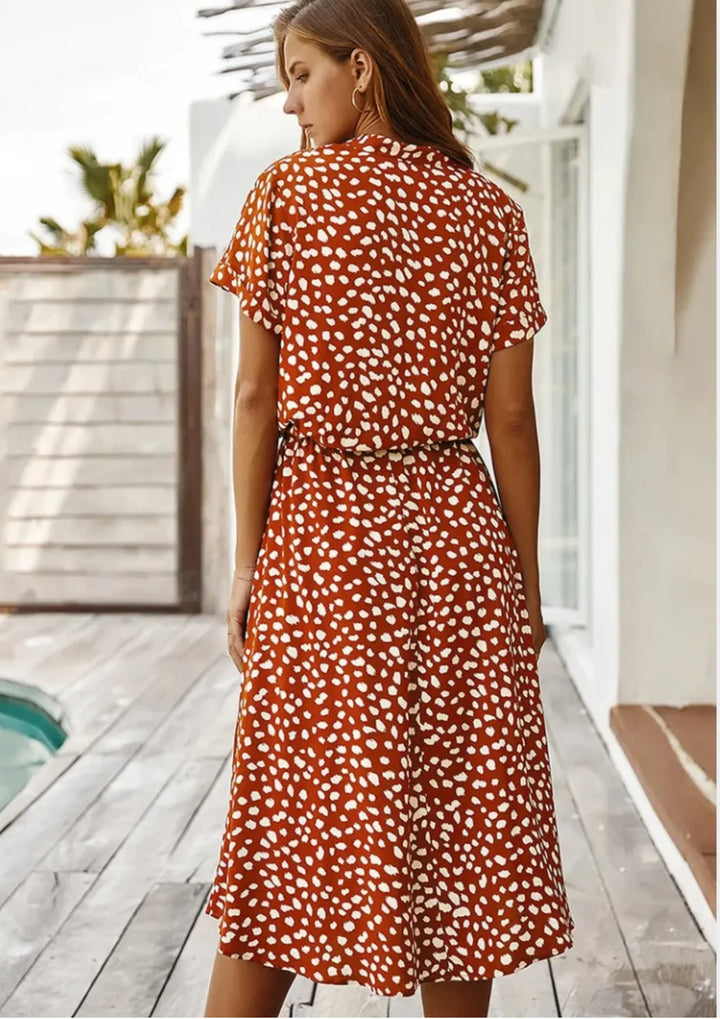 Modern women's spotted print midi dress with button-down detail and a stylish drawstring waist.