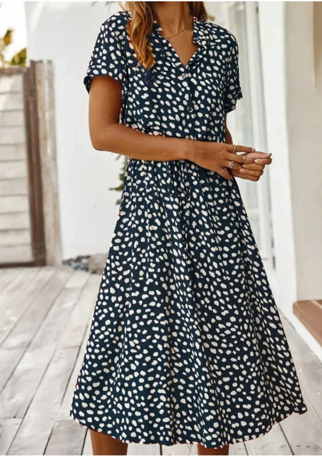 Stylish women's spotted print midi dress. Button-down front, drawstring waist, and flutter sleeves.