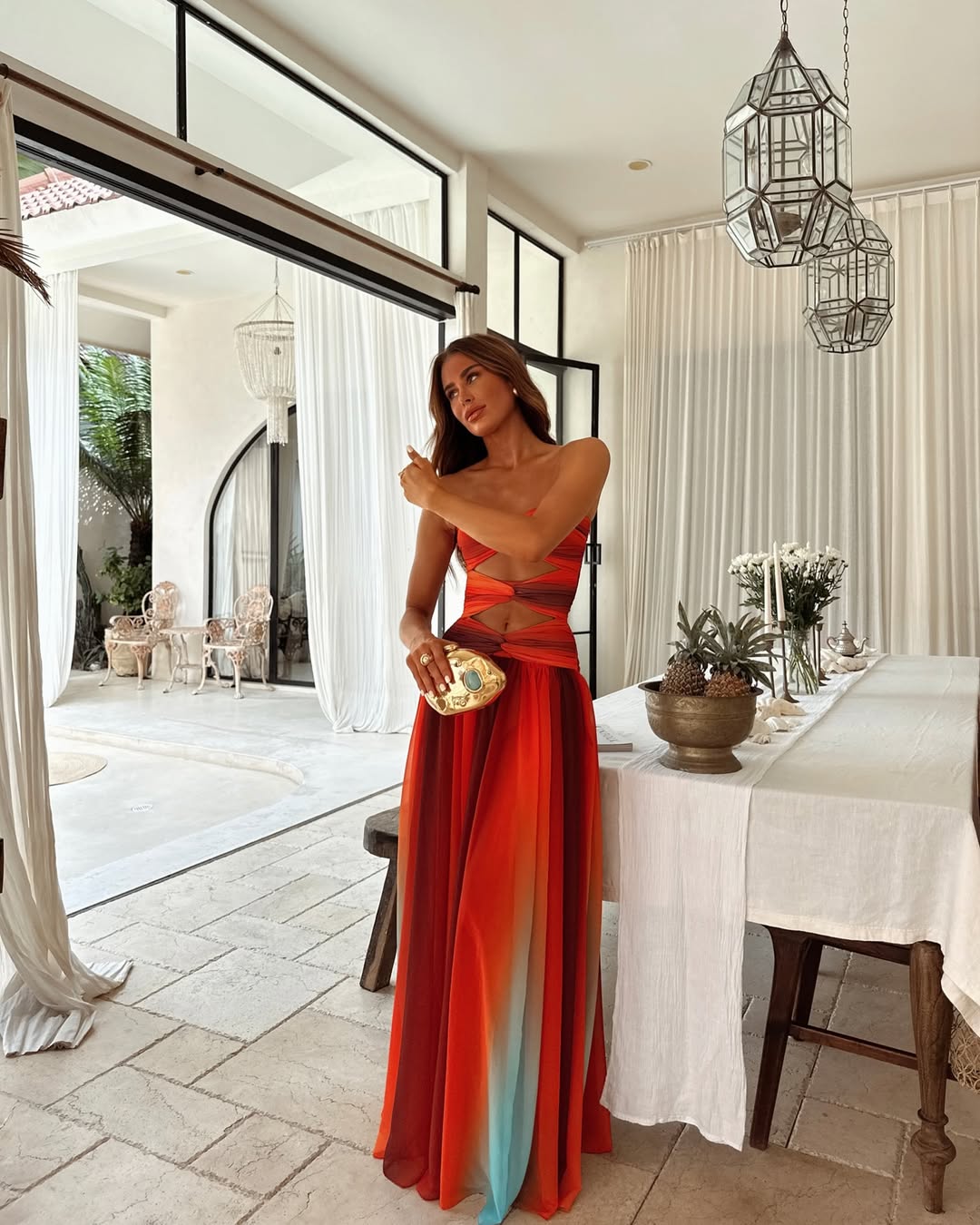 Elegant women's strapless maxi dress with stylish cut out detail & flowing skirt for summer events.