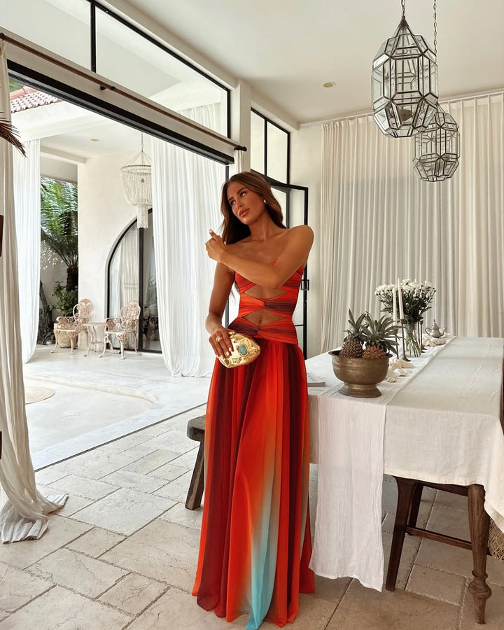 Elegant women's strapless maxi dress with stylish cut out detail & flowing skirt for summer events.