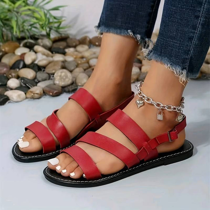 Close-up of comfortable women's open-toe flat sandals with adjustable ankle strap.