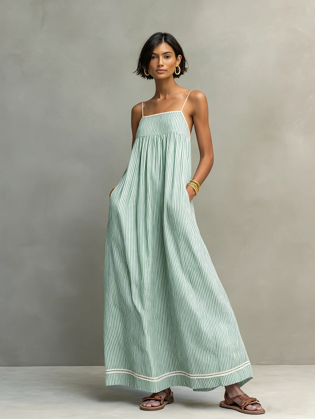 Women's sleeveless striped maxi dress with spaghetti straps & gathered waist for effortless summer style.