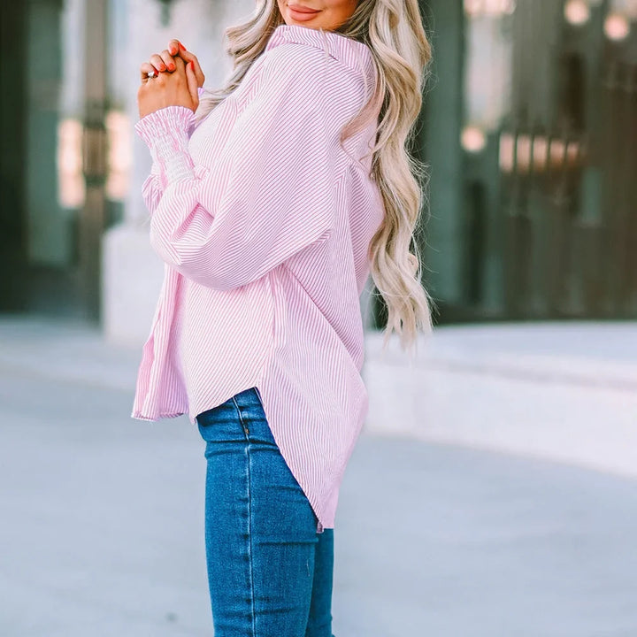 Close-up of a women's striped oversized button-down shirt, highlighting shirred balloon sleeves.