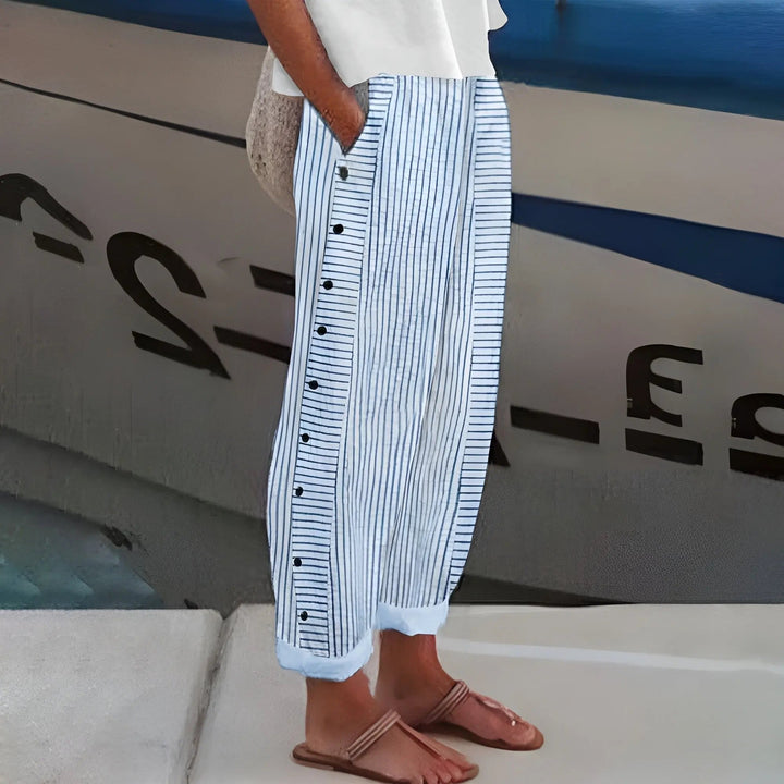 Women's striped trousers with elastic waist & decorative side buttons. Relaxed fit, comfortable for casual everyday wear.