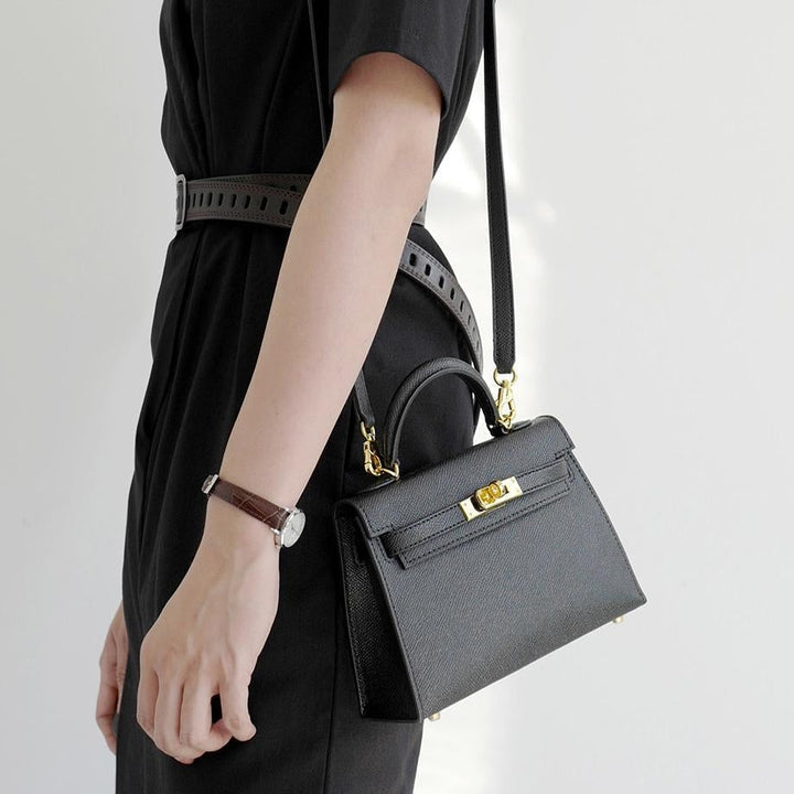 Versatile women's top handle bag with a structured silhouette and secure gold lock. A must-have accessory.